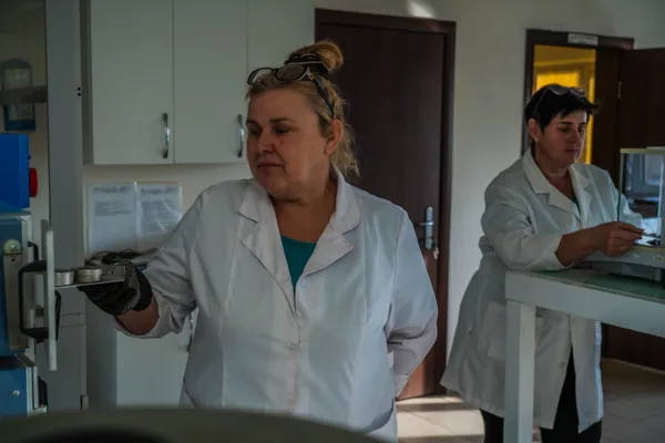 Лаборант із зразком — ширший ракурс