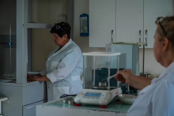 Двоє лаборантів за вагами та приладами